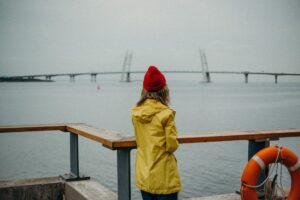 femme portant un imperméable face à la mer